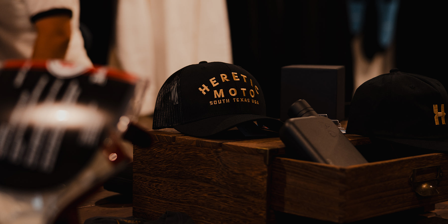 heretic-moto-trucker-hat-gold-on-table